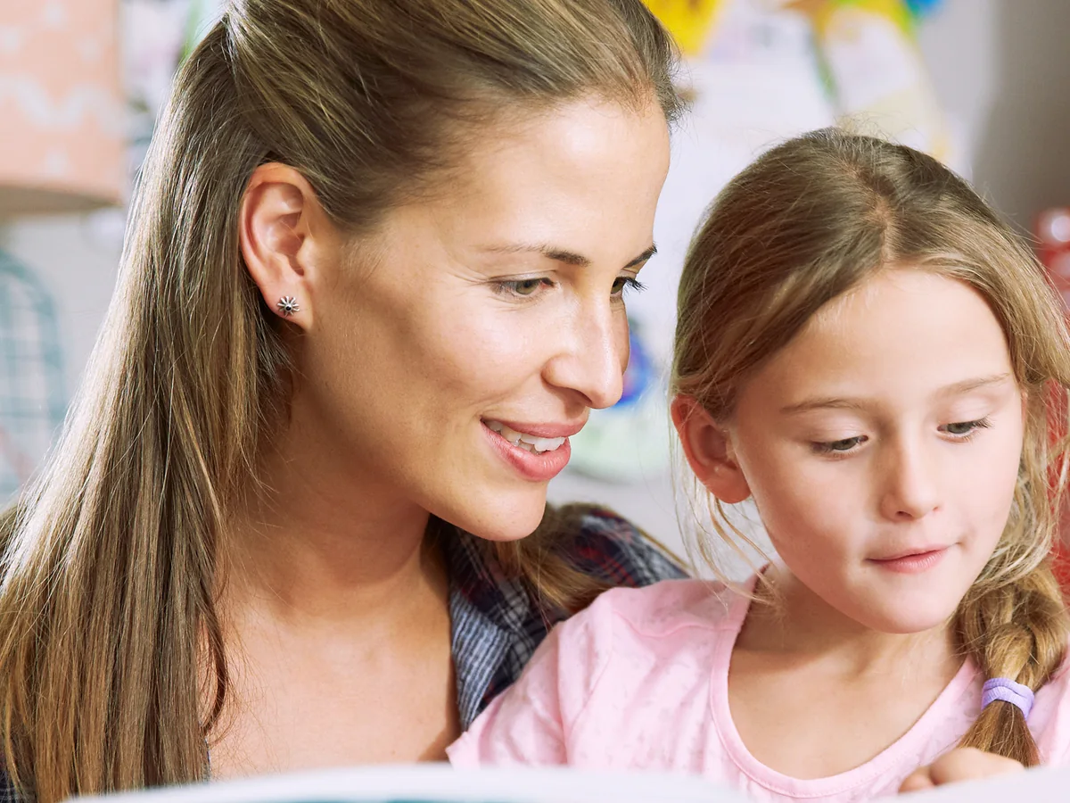 A mother and daughter reading together during a learning activity at home